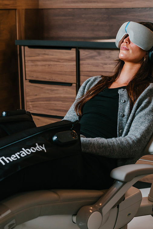 Woman using a Therabody machine in dental chair