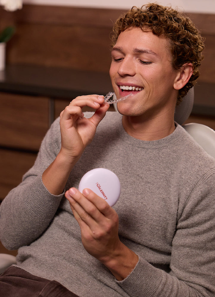 Man inserting clear aligners into mouth
