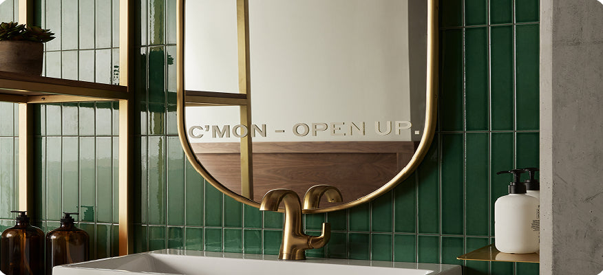 Bathroom with a decorative mirror and green tiles